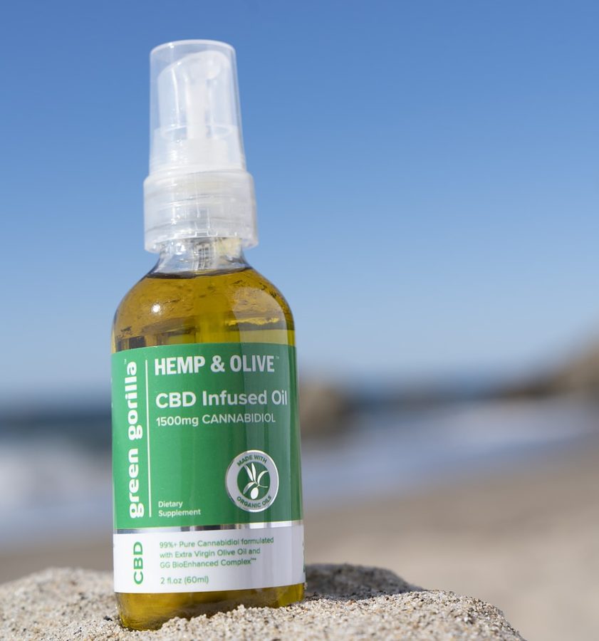 Pure 1500mg CBD oil sitting on the sand at the beach