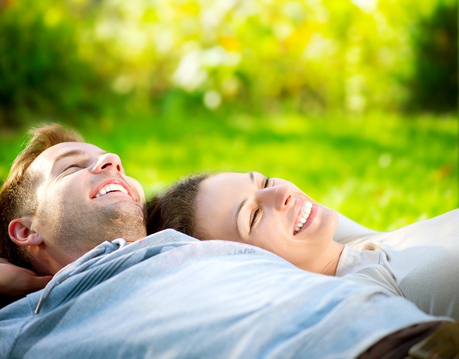 Park. Young Couple Lying on Grass Outdoor