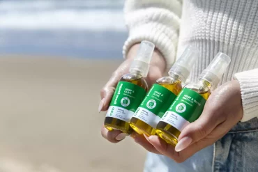 woman holding different types of CBD, bottles of liquid oil in her hands
