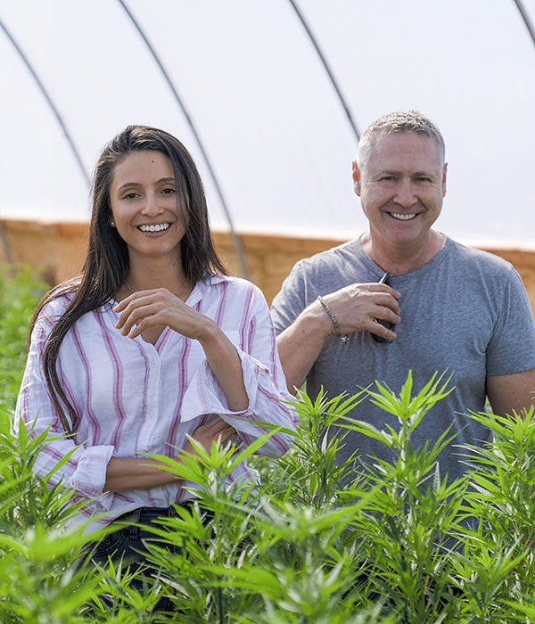 Sir Steven Saxton and Katherine Guevara Saxton standing in a hemp greenhouse.