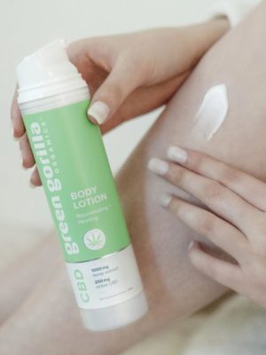 A person massaging CBD lotion onto their leg