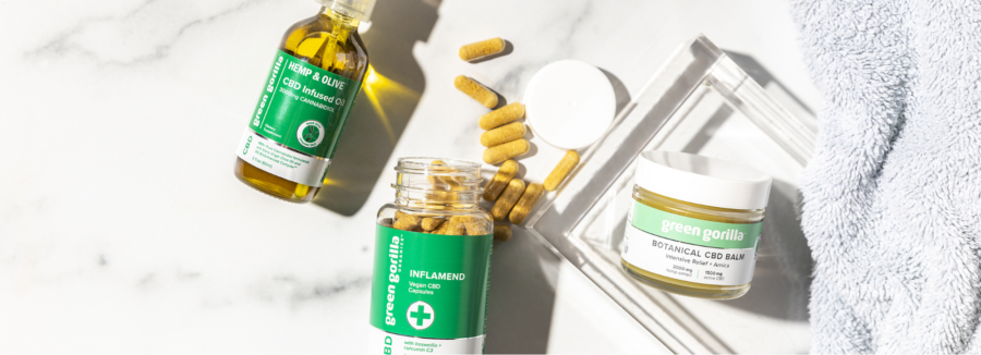 An open bottle of Green Gorilla™ CBD capsules with CBD balm and oil