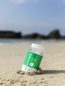 Bottle of Green Gorilla™ 10mg CBD Relax capsules nestled in the sand on the beach